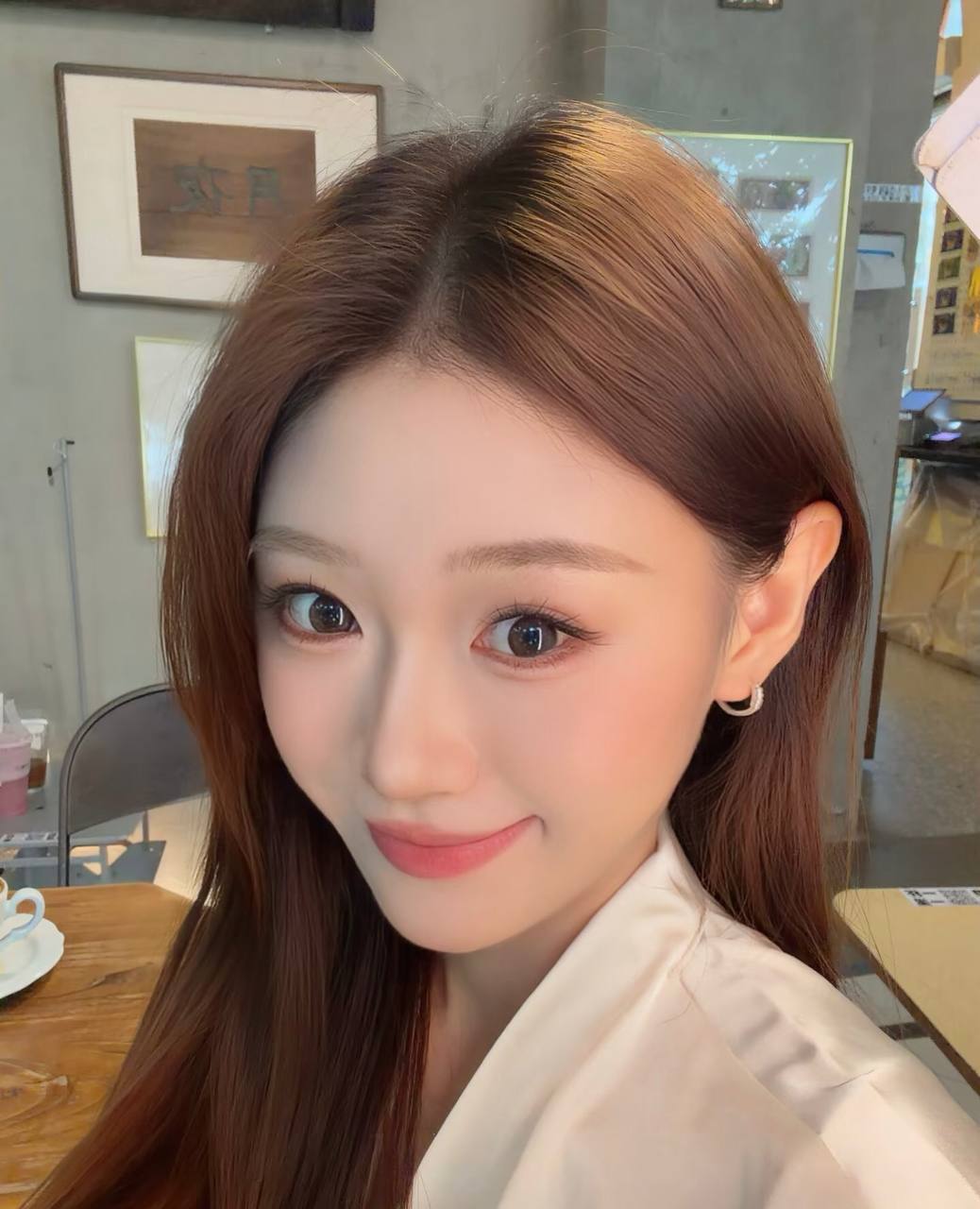 Close-up portrait in a white shirt at a cafe, looking back with a smile